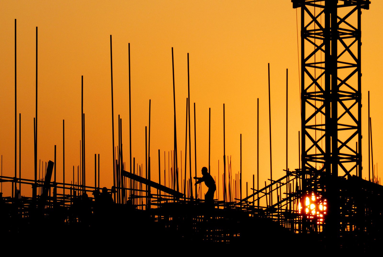 Construction workers at sunset.